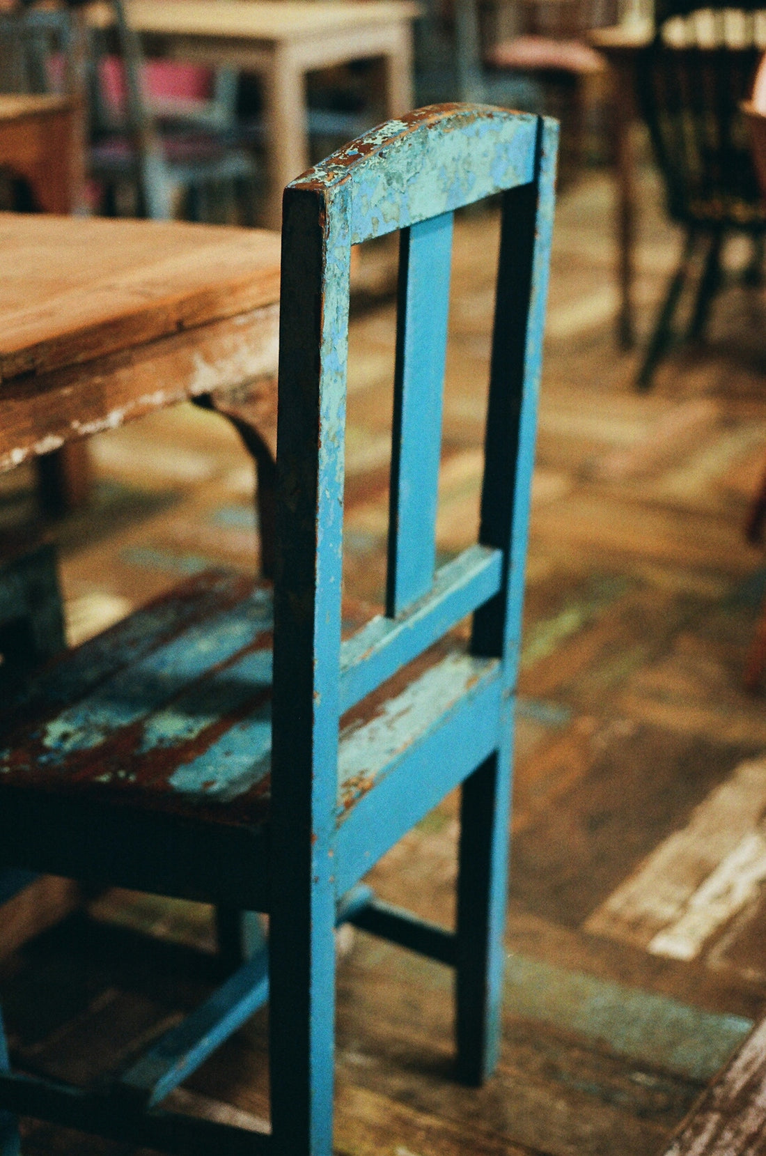 A rustic blue wooden chair next to a table